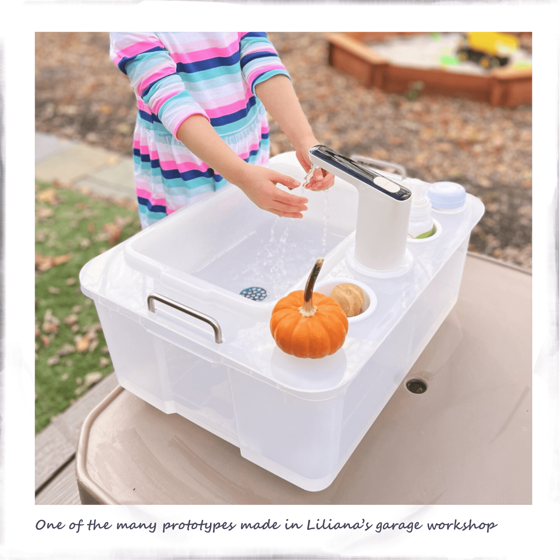 Child washing her hands using a portable sink prototype in the backyard after playing in the sandbox
